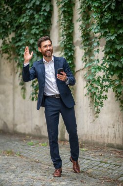 Selamlar. Zarif genç adam selamlıyor ve el sallıyor.