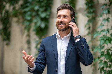 Telefon var. Yakışıklı bir genç adam telefonda konuşuyor ve olaya dahil gibi görünüyor.