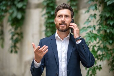 Telefon var. Yakışıklı bir genç adam telefonda konuşuyor ve olaya dahil gibi görünüyor.