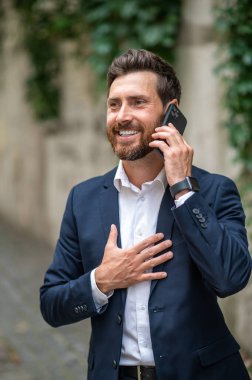 Telefon var. Yakışıklı genç adam telefonda konuşuyor ve heyecanlı görünüyor.