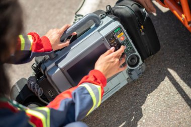 Deneyimli bir ambulans doktorunun elektrokardiyografı açarken çekilmiş fotoğrafı.