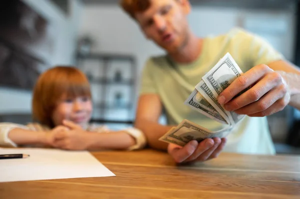 Financial literacy. Dad teaching his little son the financial basics