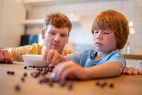 朝食前に遊ぶ 父と息子は朝食前に台所で一緒に時間を過ごす — ストック写真