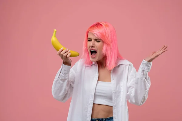 金属製のブレースと舌を持つ若い女性が果物マイクに歌をピアス — ストック写真