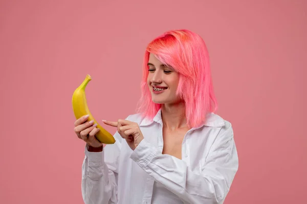 Uśmiechnięta Młoda Kobieta Metalowym Aparatem Zęby Kolczykiem Nosie Stukająca Bananowym — Zdjęcie stockowe