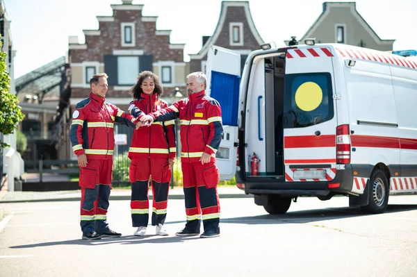 Smiling Female Paramedic Her Colleagues Standing Outdoors Stacking Hands Palms Stock Picture