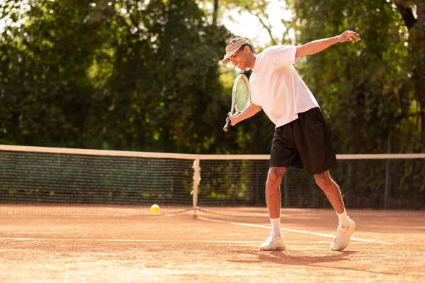 テニスをしている 若いです男で白いTシャツとともにテニスラケットで手 — ストック写真