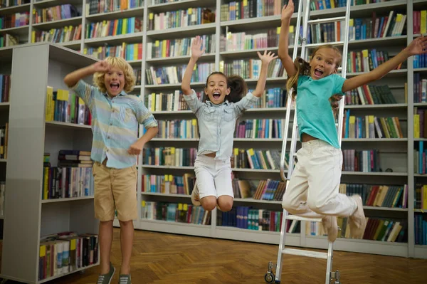 快乐的孩子们在图书馆里的一群可爱的孩子看上去很开心很开心 — 图库照片