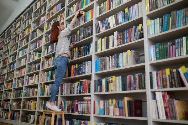 Procura Livro Jovem Bibliotecário Busca Livro Sobre Estantes — Fotografia de Stock