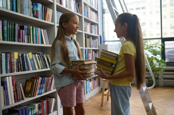 Szukamy Książek Dwie Słodkie Dziewczyny Szkole Szuka Książek Bibliotece — Zdjęcie stockowe