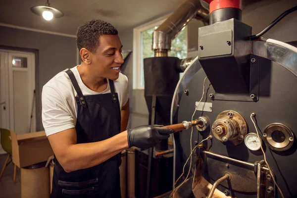 Kavurucu Kızartma Makinesinden Kaşık Kavrulmuş Kahve Çekirdeklerini Çıkarıyor — Stok fotoğraf
