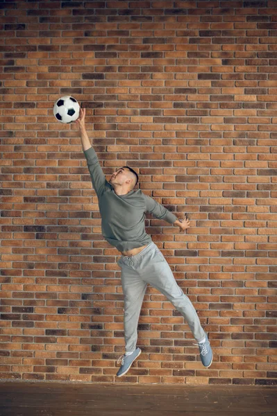 Полноразмерный Портрет Сфокусированного Спортивного Молодого Азиата Прыгающего Футбольный Мяч — стоковое фото
