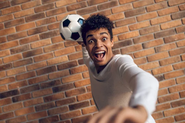 Кричащий Игрок Стоящий Кирпичной Стены Бросающий Мяч Одной Рукой Сзади — стоковое фото