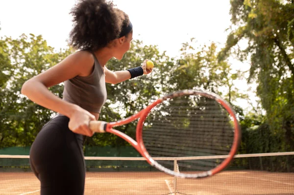 Tenis Kıvırcık Saçlı Bayan Tenisçi Oynuyor Konsantre Görünüyor — Stok fotoğraf