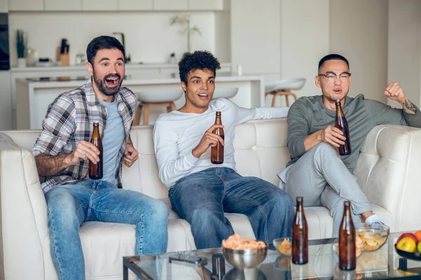 Tres Hombres Con Botellas Cerveza Sentados Sofá Viendo Partido Fútbol — Foto de Stock