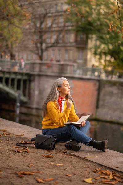 Sanatçı Nehir Kıyısında Oturan Albüm Çizen Olgun Bir Kadın — Stok fotoğraf