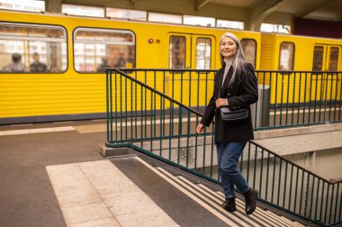 Varış yeri. Metrodan çıkan siyah paltolu kadın.