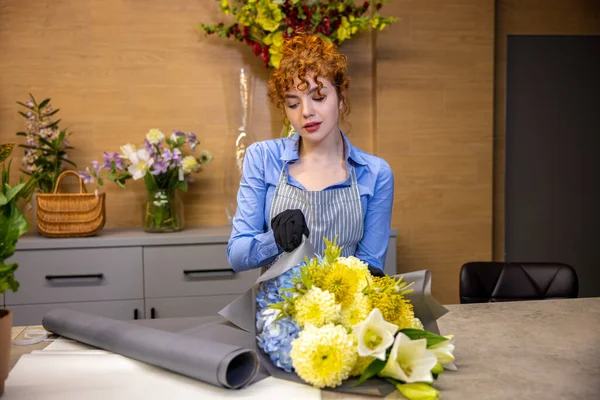 Bir Çiçekçide Çiçekçinin Masasında Duran Tatlı Kızıl Genç Bir Kadın — Stok fotoğraf