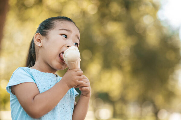 Tasty ice-cream. Cute little girl eating ice-cream and looking contented