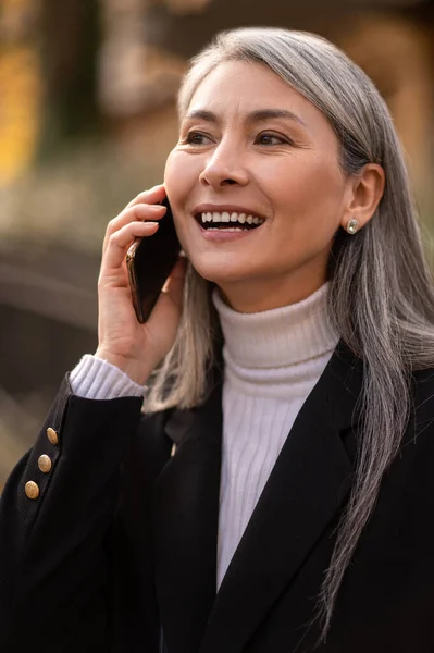 任命前の予想 待望のスマートフォンを持つ長髪の中高年女性 — ストック写真