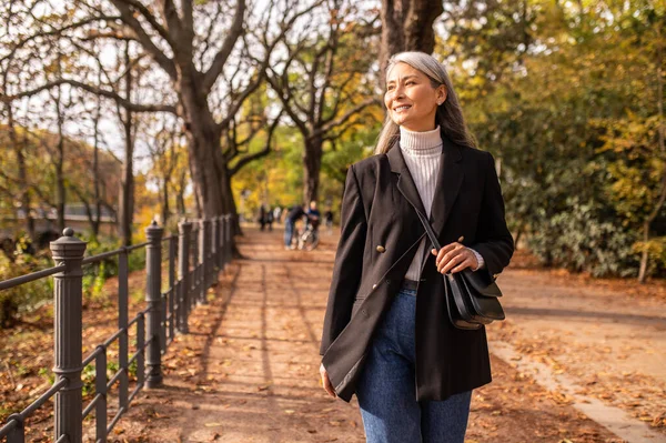 stock image In the park. Long-haired pretty woman walking in the park