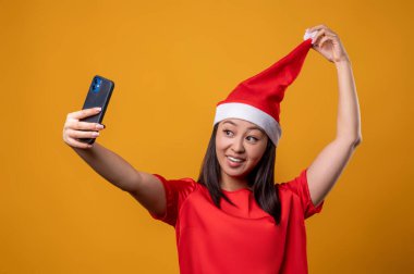 Selfie. Asyalı tatlı bir kadın selfie çekiyor ve poz veriyor.