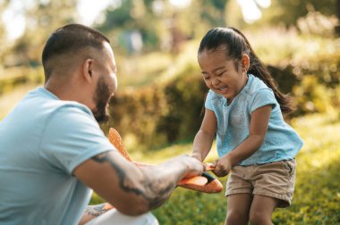 Oyuncak uçak. Genç adam çocuğuna oyuncak uçakla nasıl oynanacağını gösteriyor.