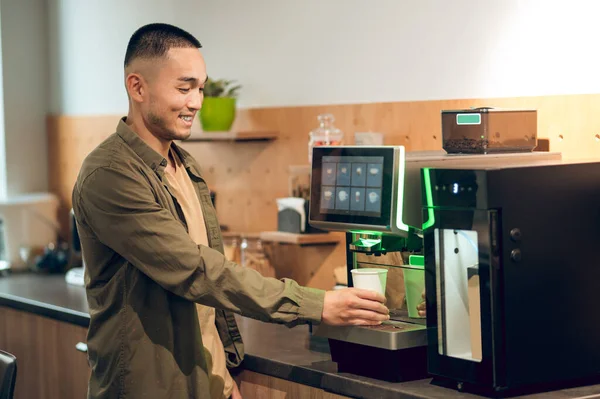 Gülümseyen Asyalı Adam Tek Kullanımlık Kağıt Bardağı Kahve Makinesine Damlatıyor — Stok fotoğraf