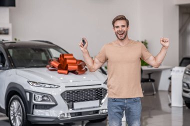 Yeni araba. Bir araba galerisinde mutlu ve heyecanlı bir araba sahibi.