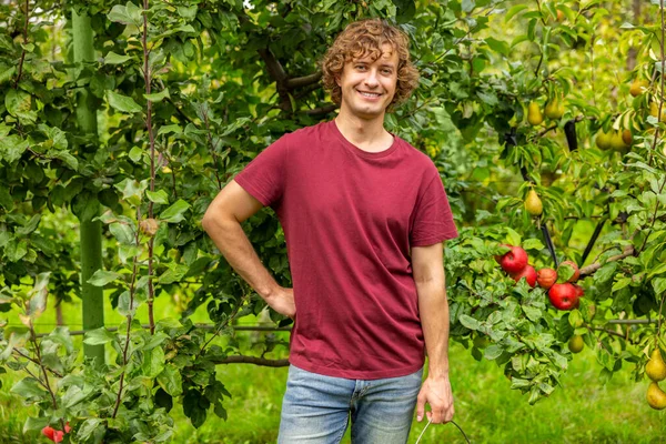 Sorrindo Alegre Jovem Orchardist Posando Para Câmera Contra Árvores Fruto — Fotografia de Stock