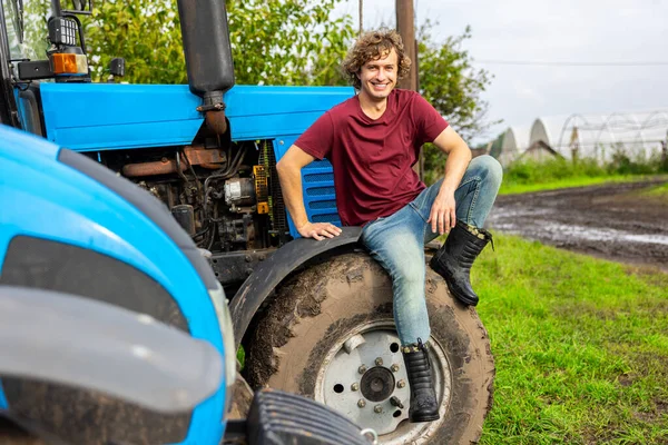 Glimlachend Tevreden Jonge Boer Zittend Het Trekkerwiel Kijkend Voor Hem — Stockfoto