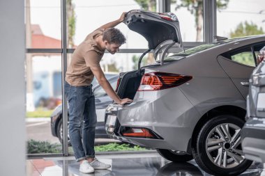 Tercih. Bir araba galerisinde Acar 'ı inceleyen genç adam.