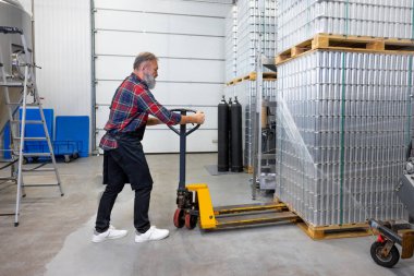 Yoğun bir gün. Ekose gömlekli adam fabrikada çalışıyor ve meşgul görünüyor.