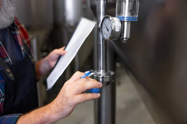 プロセス制御 タンク内の圧力をビールでチェックする醸造労働者 — ストック写真