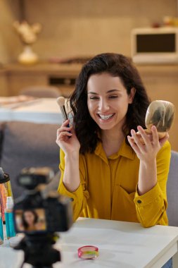 Güzellik ürünleri. Gülümseyen genç bayan internette yeni kozmetik ürünleri gösteriyor.