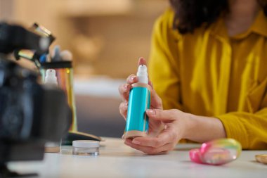 Güzellik ürünleri. Kadın masada oturuyor ve internette güzellik ürünleri gösteriyor.