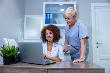 Colleagues. Two female doctors discussing something at the laptop in the clinic