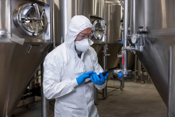 Serious Focused Brewery Technologist Standing Metal Tanks Tapping Tablet Computer — Foto Stock
