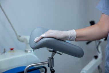 Gynecologist office. Close up of deoctors hand on a gynecological examination chair
