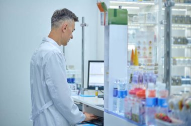 Working day. Male pharmacist in lab coat working in a drugstore