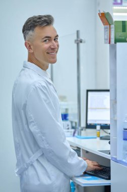 Working day. Male pharmacist in lab coat working in a drugstore