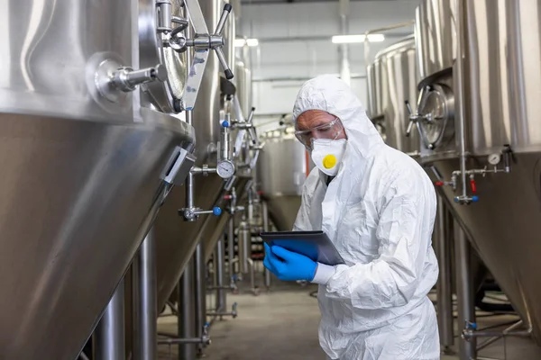 Focused Brewery Technologist Protective Mask Standing Fermentation Tanks Making Notes — Foto Stock