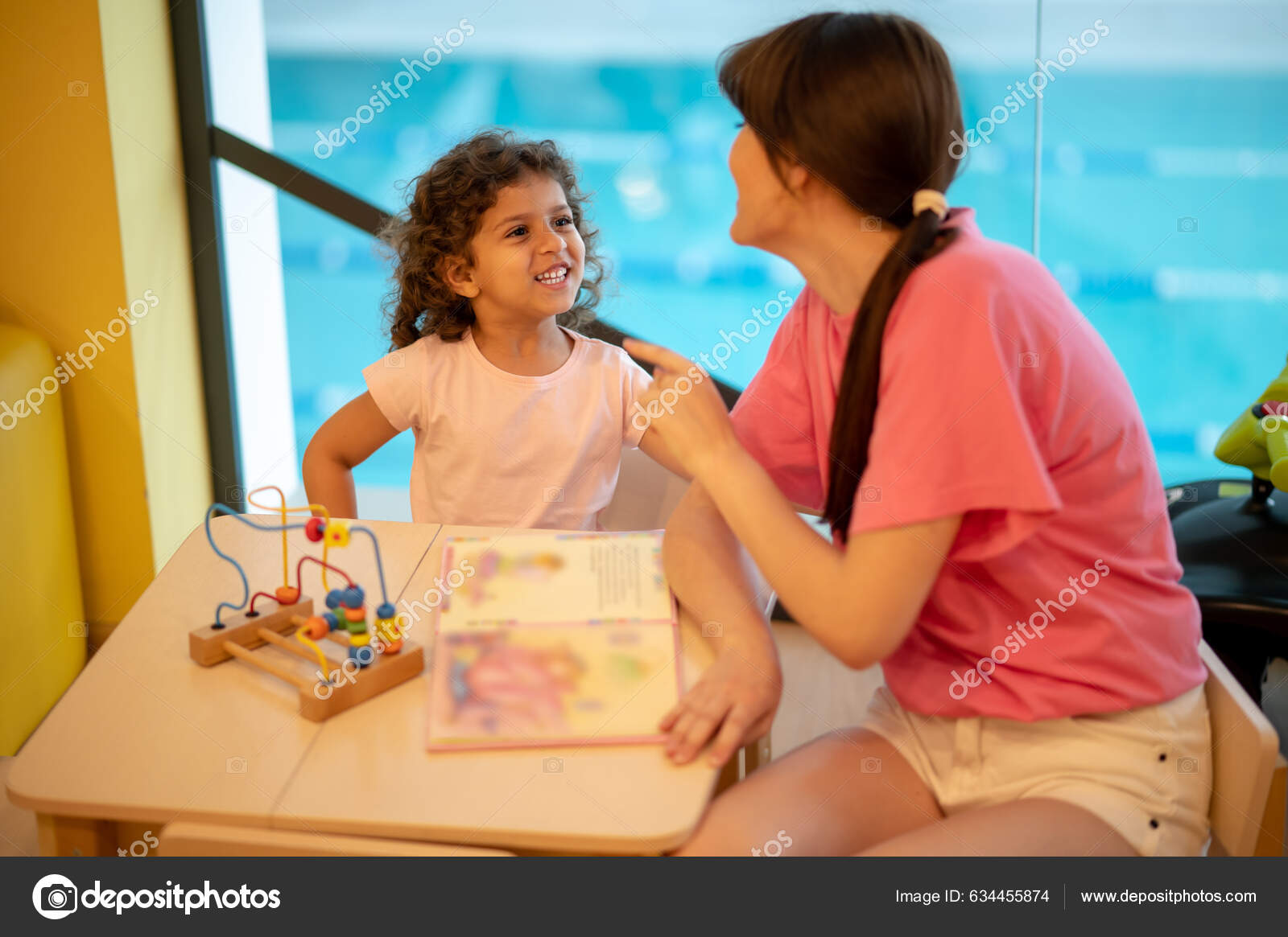 Two Girls on a Bed Playing with Their Dogs