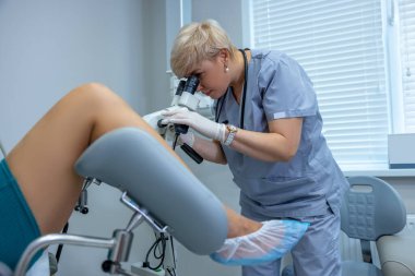 Colposcopy. Experienced gynecologist doing colposcopy to a woman