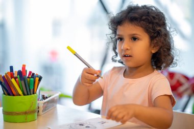 Drawing. Cute little girl drawing in a play room