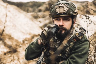 Reconnoiter. Soldier with binocular investigating the place