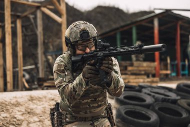 Shooting. Soldier in camouflage with a rifle in hands