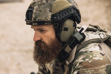 Warrior. Bearded soldier in military uniform looking determined and serious