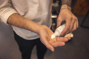 Lotion. Close up picture of barbers hands holding moisturizing lotion