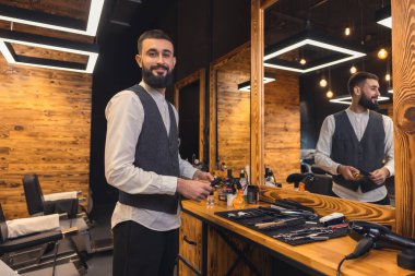 Barber at work. Barber with hairdressing tools an the barbershop